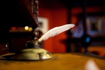 Photograph of quill pen on desk by Ross Pollack